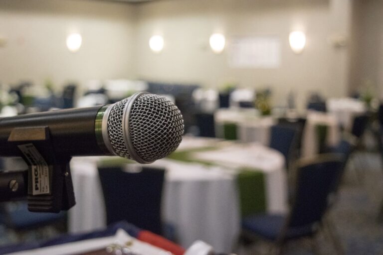 Microphone in front of round tables set up for a meeting